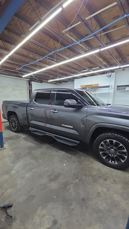 A sleek gray Toyota Tundra sits in the T’s Window Tinting shop with freshly tinted side and rear windows